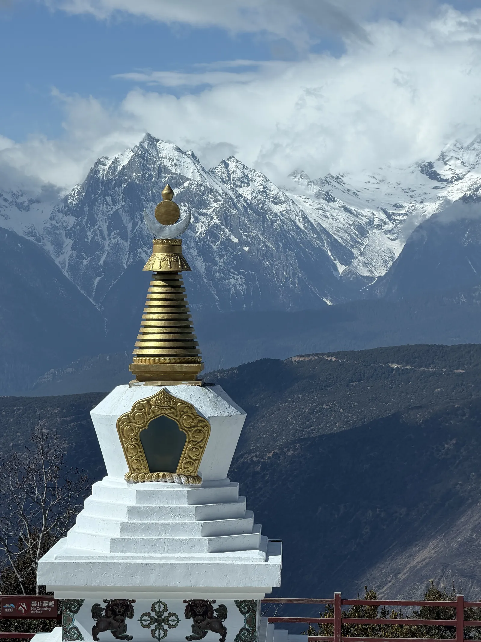 A white stupa at Wunongding with the snow-covered Meili range behind it
